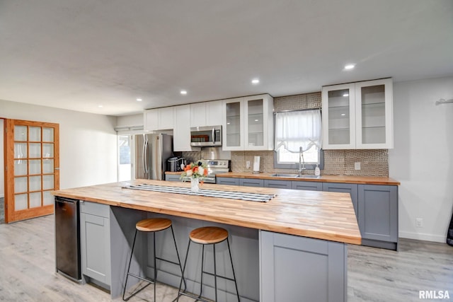 kitchen with sink, gray cabinets, stainless steel appliances, and wood counters