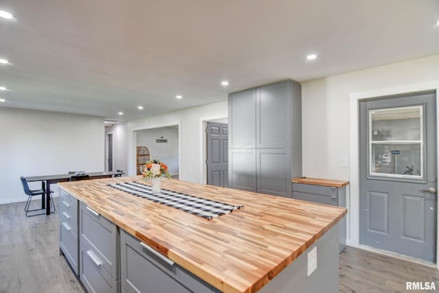 kitchen featuring wood counters, light hardwood / wood-style floors, gray cabinetry, and a center island