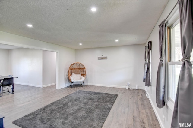 living area with wood-type flooring and a textured ceiling