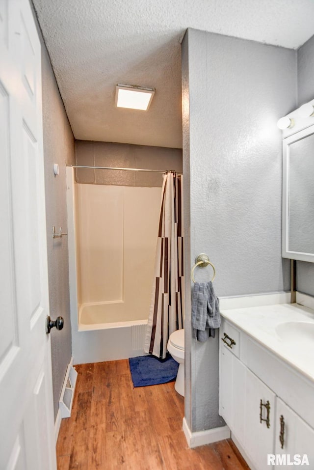 full bathroom with toilet, hardwood / wood-style flooring, a textured ceiling, and vanity