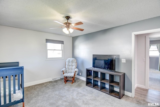 carpeted bedroom with a textured ceiling and ceiling fan