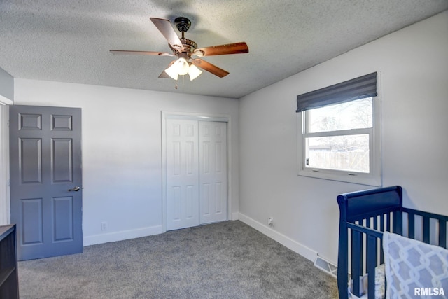 unfurnished bedroom with ceiling fan, a closet, a textured ceiling, and light colored carpet