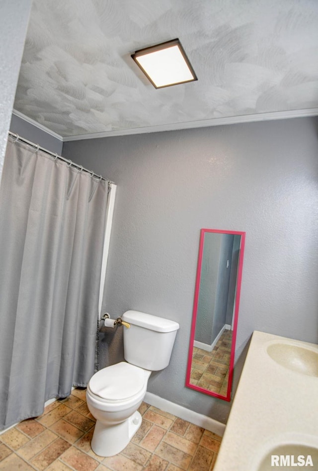 bathroom with ornamental molding, toilet, and vanity