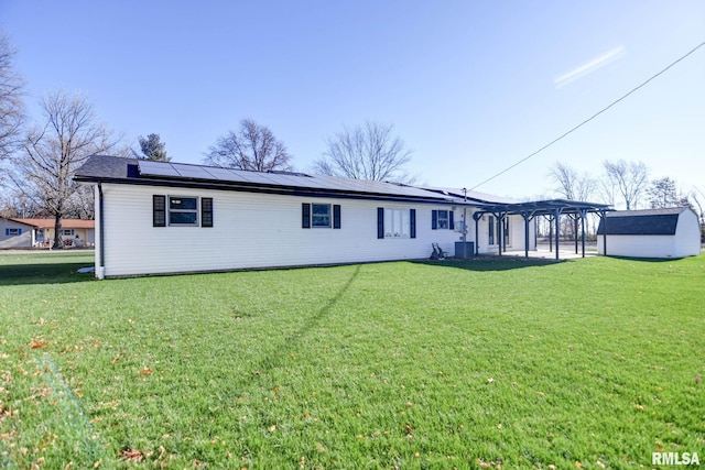 back of property featuring a pergola, a lawn, solar panels, and a storage shed