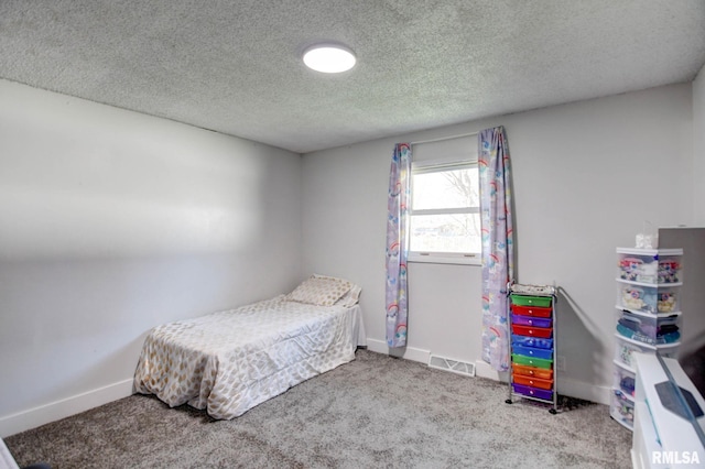 bedroom featuring a textured ceiling and carpet flooring