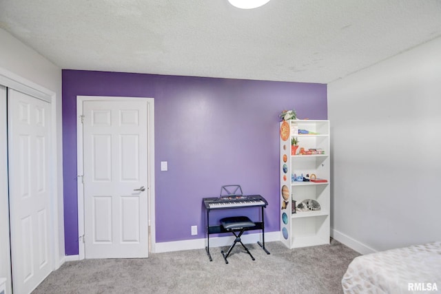 bedroom featuring a closet, light carpet, and a textured ceiling