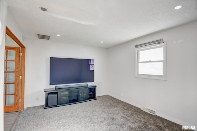 unfurnished living room featuring carpet and a textured ceiling