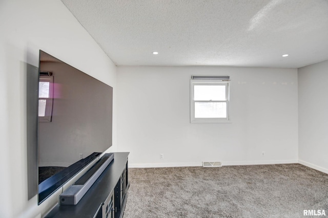 carpeted empty room with a textured ceiling