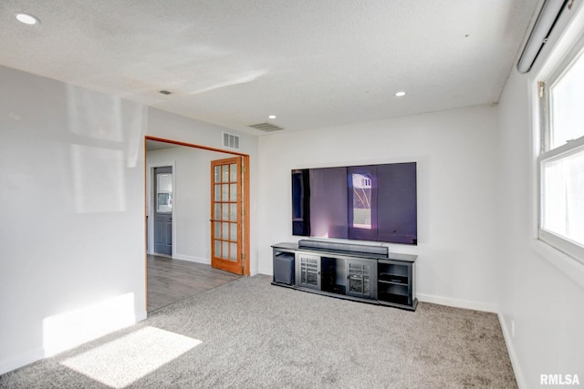 unfurnished living room featuring carpet floors and a textured ceiling