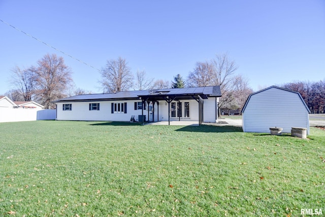 back of house with a patio area, solar panels, and a yard