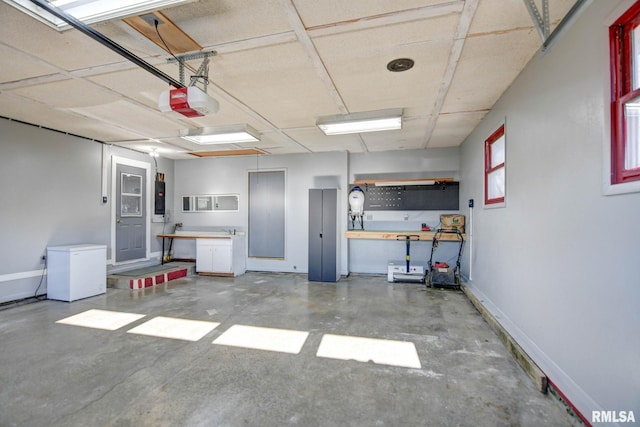 garage featuring a garage door opener, fridge, water heater, and a workshop area