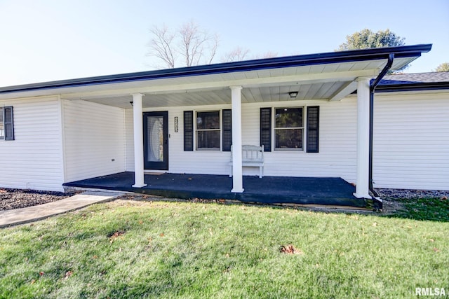 property entrance featuring a yard and a porch