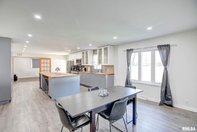 dining room with light wood-type flooring and sink