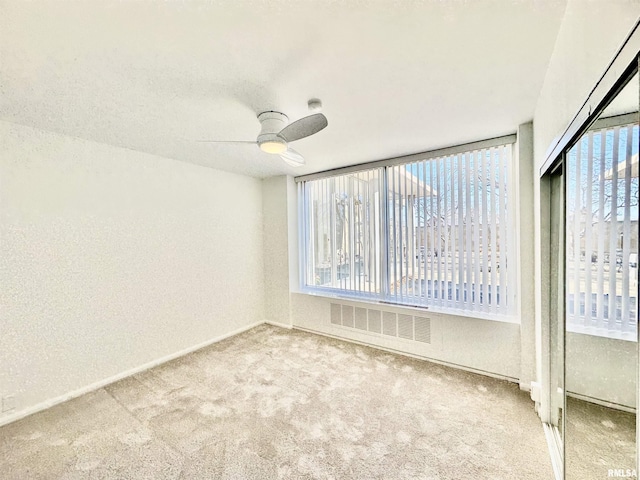 empty room featuring ceiling fan and carpet floors