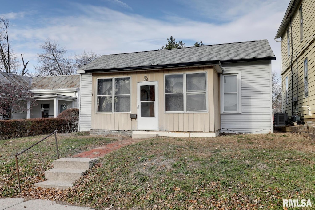 view of front of property with cooling unit and a front yard