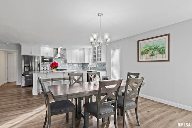 dining room featuring light hardwood / wood-style floors, a notable chandelier, and sink