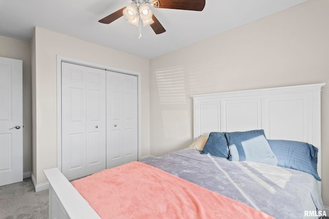 carpeted bedroom with ceiling fan and a closet