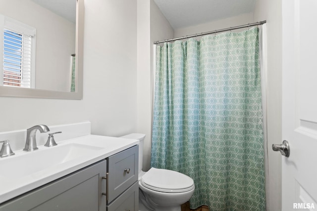 bathroom with a shower with curtain, vanity, a textured ceiling, and toilet