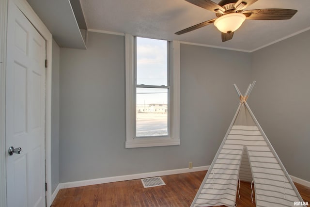 playroom with crown molding, ceiling fan, and wood-type flooring