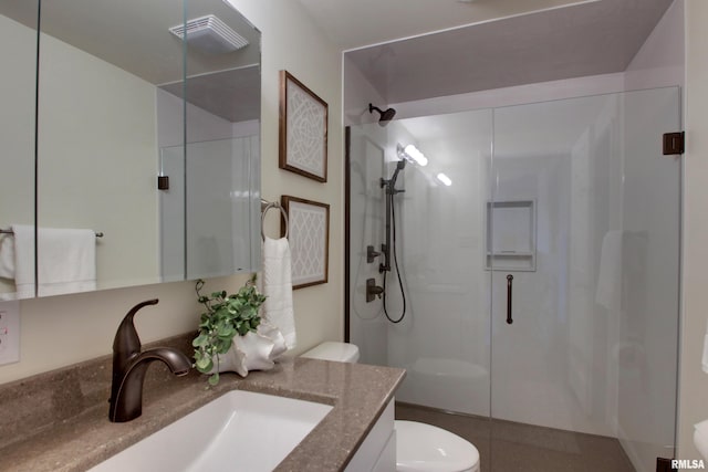 bathroom featuring vanity, toilet, and a shower with shower door