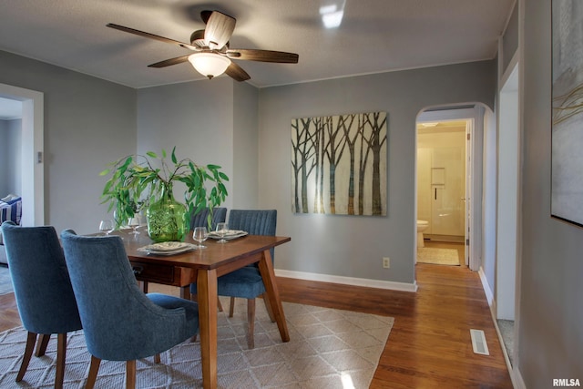 dining area with ceiling fan, wood-type flooring, and a textured ceiling