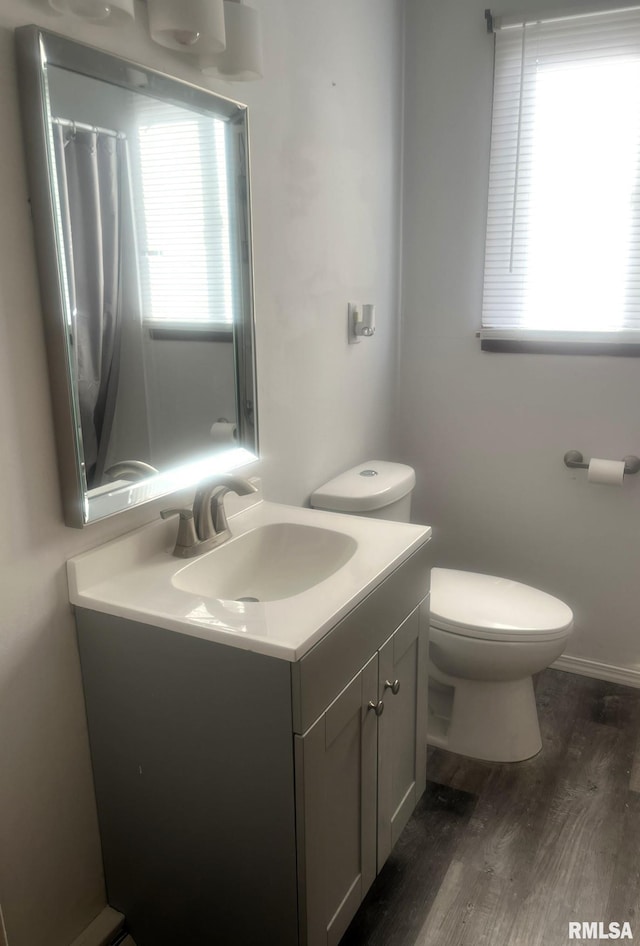 bathroom with hardwood / wood-style flooring, vanity, and toilet