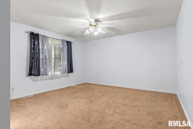 carpeted spare room with a textured ceiling and ceiling fan