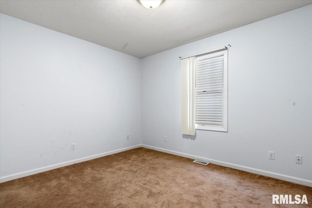 carpeted empty room with a textured ceiling