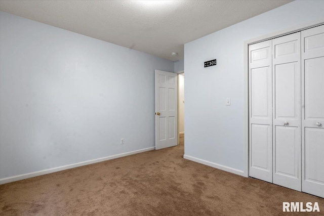 unfurnished bedroom with carpet flooring, a textured ceiling, and a closet