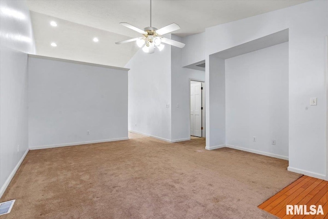 unfurnished room with ceiling fan, light colored carpet, and lofted ceiling