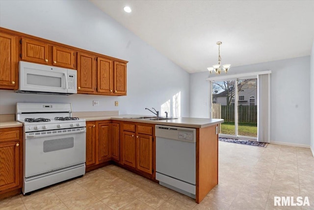 kitchen with kitchen peninsula, white appliances, sink, a chandelier, and lofted ceiling