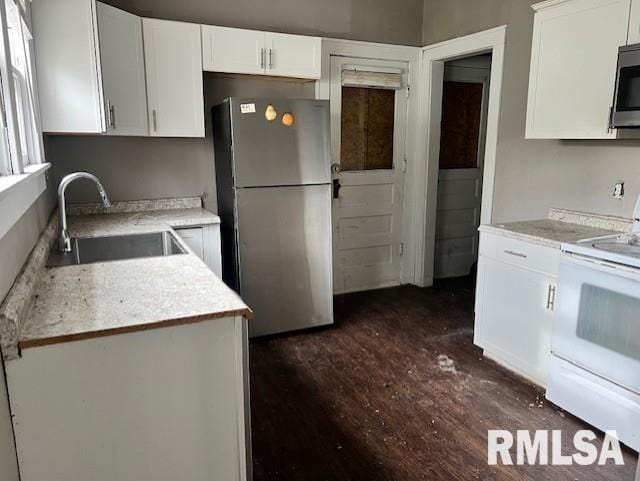 kitchen with white cabinetry, stainless steel appliances, dark hardwood / wood-style floors, and sink