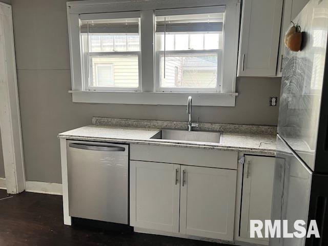 kitchen with appliances with stainless steel finishes, dark hardwood / wood-style floors, sink, and white cabinets