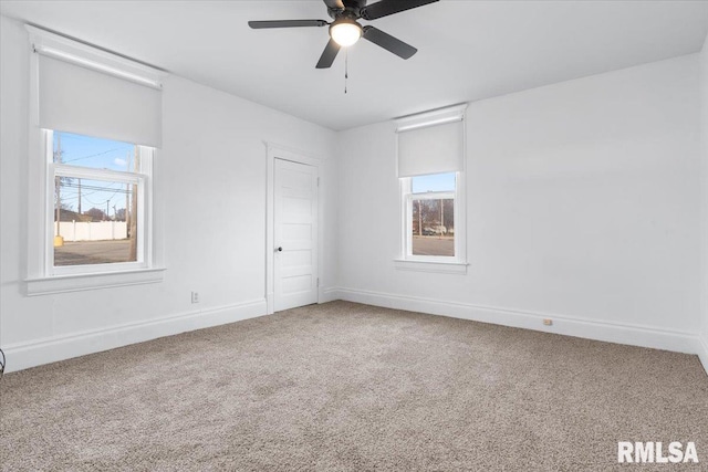 empty room featuring carpet flooring, ceiling fan, and a wealth of natural light