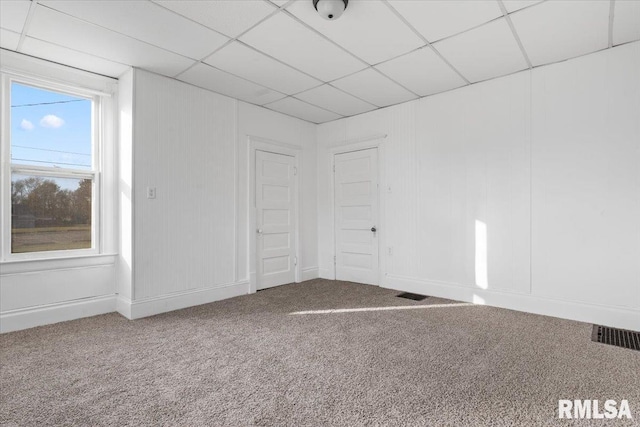 unfurnished room featuring a paneled ceiling and carpet floors