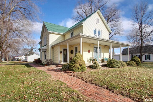 country-style home featuring a porch and a front lawn