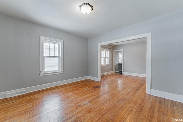 empty room with light wood-type flooring and a wealth of natural light