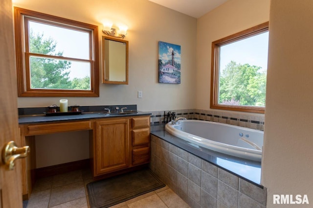 bathroom with vanity, tile patterned floors, a healthy amount of sunlight, and tiled tub