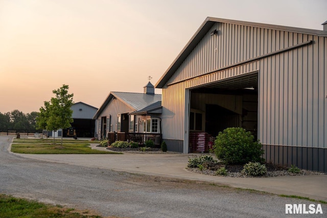 property exterior at dusk featuring an outbuilding and a garage