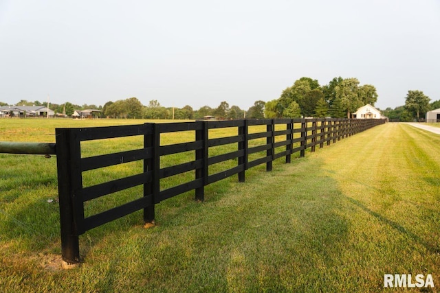 view of gate featuring a rural view and a lawn