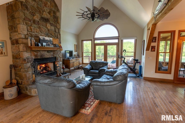 living room featuring a fireplace, high vaulted ceiling, a healthy amount of sunlight, and wood-type flooring