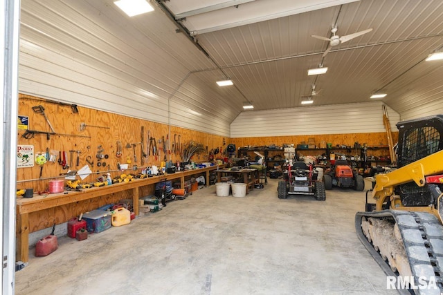 garage with a workshop area, wooden walls, and ceiling fan