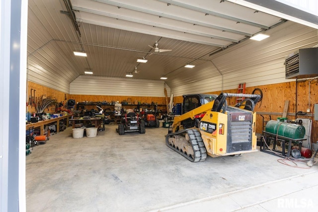 garage with a workshop area, ceiling fan, and wooden walls