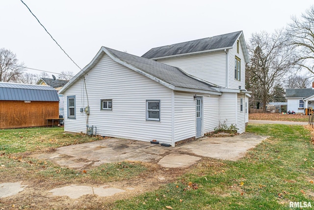 view of side of home with a yard and a patio area