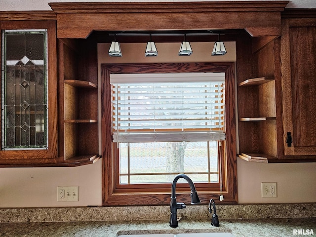 details featuring light stone countertops and sink