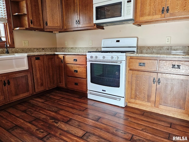 kitchen with dark hardwood / wood-style floors, white appliances, and sink