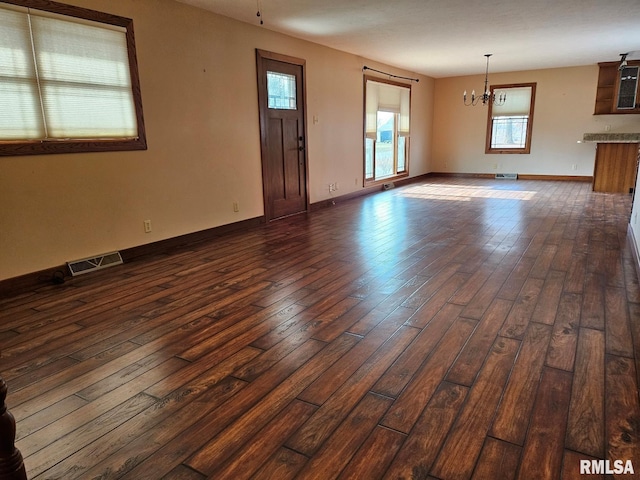 interior space featuring dark wood-type flooring and a notable chandelier