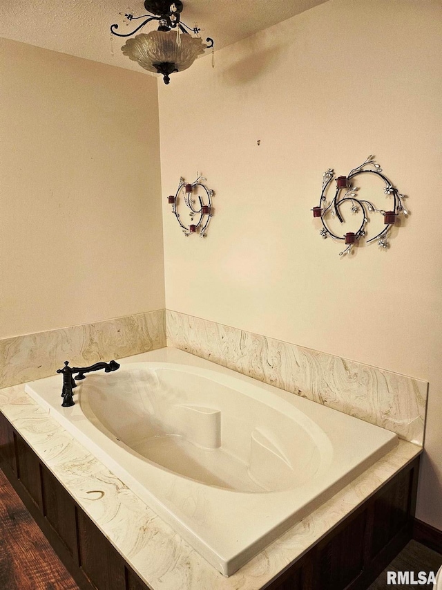 bathroom featuring a washtub and a textured ceiling