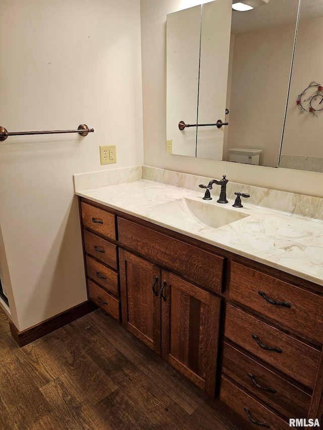 bathroom with vanity, hardwood / wood-style flooring, and toilet