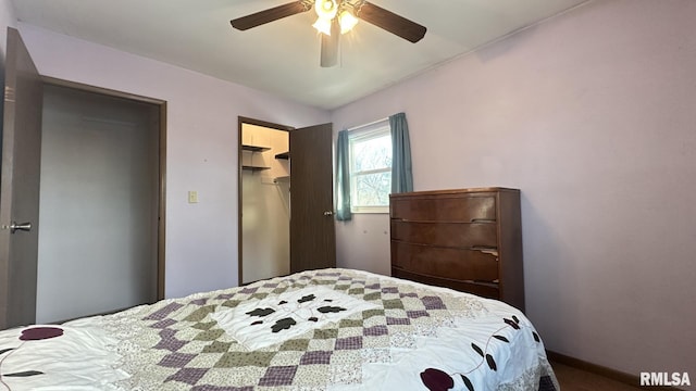 bedroom with a spacious closet, ceiling fan, and a closet